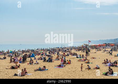 West Cliff Beach, Bournemouth, Großbritannien - 12. Mai 2024: Sonnenanbeter am Sandstrand. Stockfoto