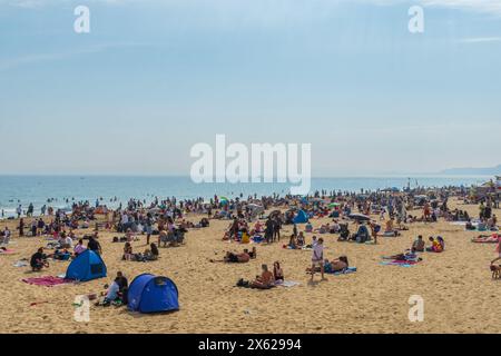 West Cliff Beach, Bournemouth, Großbritannien - 12. Mai 2024: Sonnenanbeter am Sandstrand. Stockfoto