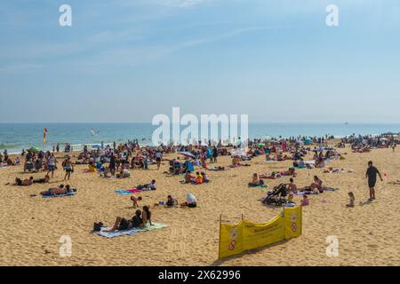 West Cliff Beach, Bournemouth, Großbritannien - 12. Mai 2024: Sonnenanbeter am Sandstrand. Stockfoto