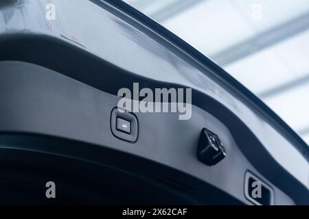 Taste für automatisches elektrisches Öffnen und Schließen der Kofferraumtür des neuen Pkw-Nahaufnahme auf hellverschwommenem Hintergrund Stockfoto
