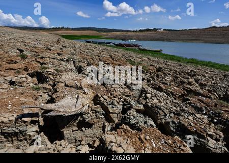 Pantabangan, Philippinen. 12. Mai 2024, Pantabangan, Philippinen: Reste der alten versunkenen Stadt Pantabangan, die wieder aufgetaucht sind, werden durch einen verwelkten Baum an einem trockenen Teil des Reservoirs gesehen, als Folge einer schweren Dürre aufgrund der steigenden Temperaturen auf den Philippinen. Das sechste Wiederauftauchen dieser 300 Jahre alten Siedlung, die eine Kirche und mehrere Grabsteine umfasst, hat Touristen zu Besuch gezogen, nachdem der Wasserstand am Damm aufgrund der El Nino Klimabildungen gesunken ist. Quelle: ZUMA Press, Inc./Alamy Live News Stockfoto