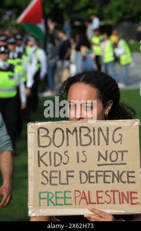 Ein Demonstrant trägt während der Demonstration ein Schild mit der Aufschrift „Kinder zu bombardieren ist keine Selbstverteidigung – freies Palästina“. In der Londoner Waterloo-Gegend wurde ein propalästinensischer Protest abgehalten, bei dem Demonstranten die Waterloo Bridge für eine gewisse Zeit geschlossen hatten. Die Demonstration wurde von der Youth Demand organisiert und von Gesundheitspersonal für Palästina unterstützt. Sie fordern ein Waffenembargo mit Israel und die Einstellung der Bombardierung Rafahs. Israel verfolgt den Gazastreifen über sechs Monate seit Kriegsbeginn weiter. Stockfoto