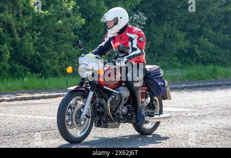 Stoke Goldington, UK - 11. Mai 2024: 1975 rote Moto Guzzi 850 klassische Motorradfahrt auf einer britischen Straße Stockfoto