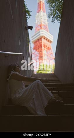 Wunderschöne hispanische Frau in Brille auf Treppen, ein Porträt der städtischen Moderne an tokios berühmtem Turmspot Stockfoto