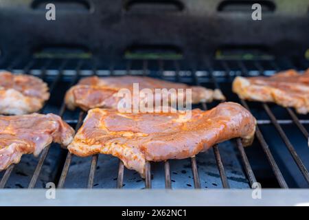 Ein Grill mit Fleisch drauf. Das Fleisch ist braun und hat viel Würze Stockfoto