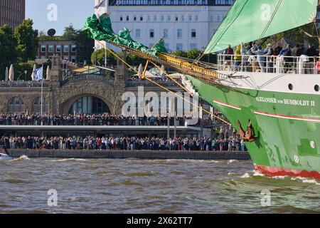 Hamburg, Deutschland. Mai 2024. Das Jugendsegel-Trainingsschiff Alexander von Humboldt II fährt während der Abfahrtsparade zum 835. Hamburger Hafengeburtstag auf der Elbe im Hafen. Die Stege mit zahlreichen Zuschauern sind im Hintergrund zu sehen. Die Hamburger betrachten den 7. Mai 1189 als Geburtsdatum ihres Hafens – damals erhielten die Bürger für ihre Schiffe auf der Elbe von der Stadt bis zur Nordsee zollfrei. Quelle: Georg Wendt/dpa/Alamy Live News Stockfoto