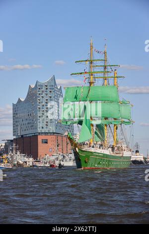 Hamburg, Deutschland. Mai 2024. Das Jugendsegel-Ausbildungsschiff Alexander von Humboldt II und andere Schiffe segeln während der Abfahrtsparade zum 835. Hamburger Hafengeburtstag entlang der Elbe im Hafen. Im Hintergrund ist die Elbphilharmonie zu sehen. Die Hamburger betrachten den 7. Mai 1189 als Geburtsdatum ihres Hafens – damals erhielten die Bürger für ihre Schiffe auf der Elbe von der Stadt bis zur Nordsee zollfrei. Quelle: Georg Wendt/dpa/Alamy Live News Stockfoto