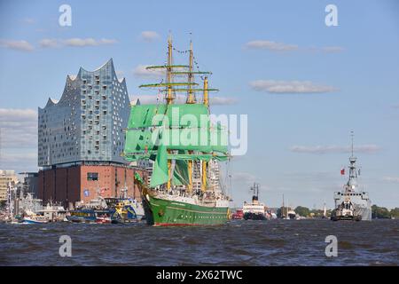 Hamburg, Deutschland. Mai 2024. Das Jugendsegel-Ausbildungsschiff Alexander von Humboldt II und andere Schiffe segeln während der Abfahrtsparade zum 835. Hamburger Hafengeburtstag entlang der Elbe im Hafen. Im Hintergrund ist die Elbphilharmonie zu sehen. Die Hamburger betrachten den 7. Mai 1189 als Geburtsdatum ihres Hafens – damals erhielten die Bürger für ihre Schiffe auf der Elbe von der Stadt bis zur Nordsee zollfrei. Quelle: Georg Wendt/dpa/Alamy Live News Stockfoto