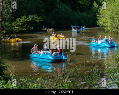 Clecy, Normandie Frankreich, 10. Mai 2024. Tretboote mit Menschen an einem sonnigen Tag auf dem Fluss Clecy in der Normandie, Nordfrankreich. Entspannung Ruhe gegen Stockfoto