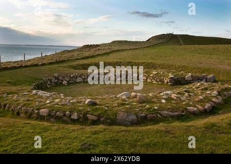 Dinas Dinlle grub Überreste eines eisenzeitlichen Hauses mit dem irischen Meer im Hintergrund aus. Dinas Dinlle liegt an der Nordwales Küste in Gwynedd. Stockfoto