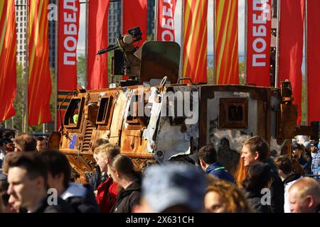 Verbrannte australische geschützte Mobilitätsfahrzeug Bushmaster und Menschenmenge auf der Ausstellung von militärischen Trophäen der russischen Armee auf dem Poklonnaja-Hügel Stockfoto