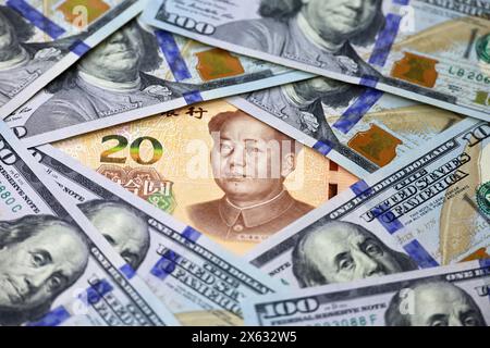 Chinesische Yuan-Banknote, umgeben von US-Dollar. Konzept des Handelskrieges zwischen China und USA, Wirtschaft, Sanktionen Stockfoto