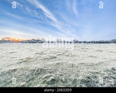 Feld mit Frost bedeckt unter blauem Himmel, wenn die Sonne aufgeht. UK Stockfoto