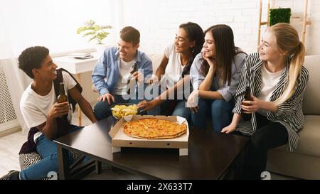 Gruppe Teenager essen Pizza am Tisch, Inneneinrichtung Stockfoto