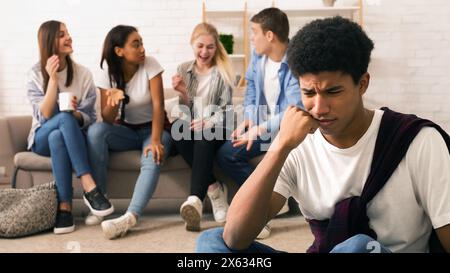 Teenager, der sich ängstlich fühlt, während die Gruppe von Freunden lacht Stockfoto