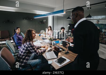 Ein vielseitiges Team von Fachleuten, das an einem Geschäftstreffen in einem modernen Büroumfeld teilnimmt Stockfoto