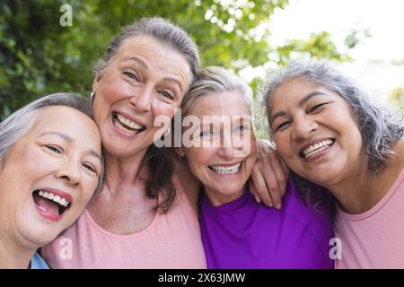 Draußen lächeln verschiedene ältere Freundinnen zusammen Stockfoto