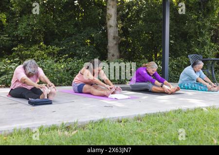 Draußen, verschiedene ältere Freundinnen dehnen sich aus Stockfoto