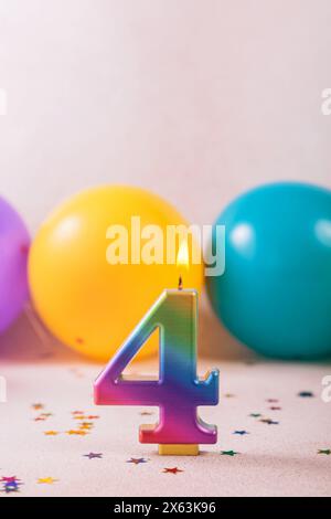 Kerze zum vierten Geburtstag und Ballons Stockfoto