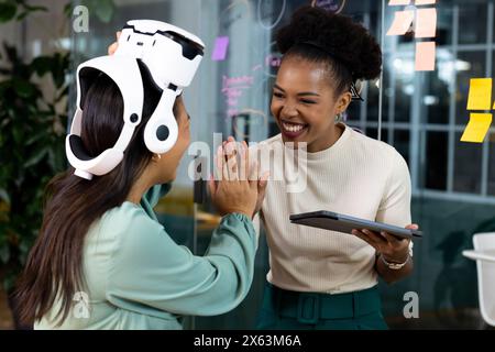 Im Büro feiern verschiedene weibliche Geschäftskollegen zusammen und arbeiten bis spät Stockfoto