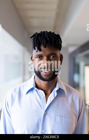 Ein Afroamerikaner mittleren Alters, der im Büro in die Kamera lächelt Stockfoto