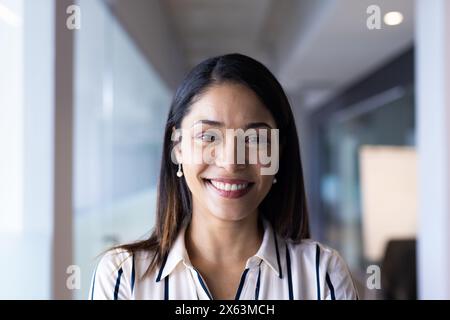 Birassische Frau mittleren Alters mit dunklen Haaren, braunen Augen, lächelt in die Kamera im Büro Stockfoto