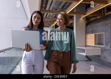 Verschiedene Teammitglieder laufen im Büro zusammen und tragen glatte Haare Stockfoto