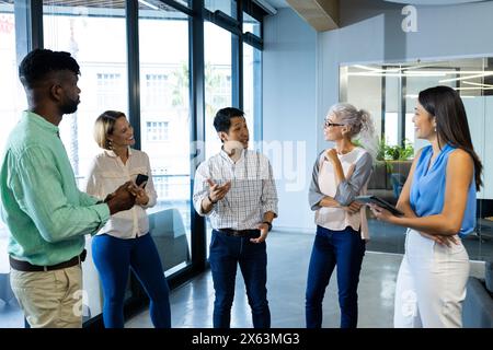 Ein vielseitiges Team, das die Arbeit im Büro diskutiert, einschließlich männlicher afroamerikanischer Manager Stockfoto