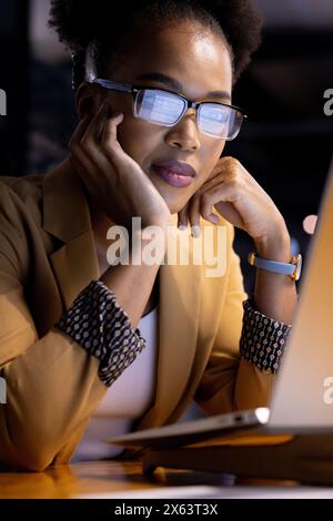 Afroamerikanische Geschäftsfrau mit Brille, die spät im Büro arbeitet Stockfoto