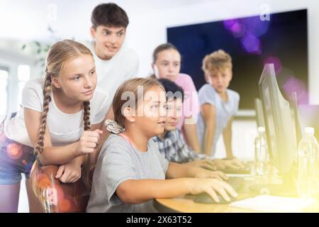 Computerunterricht im Klassenzimmer - Klassenkameraden lösen Probleme am Computer gemeinsam Stockfoto