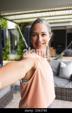 Zu Hause, reife Kaukasierin, die legere Kleidung trägt und Yoga macht Stockfoto