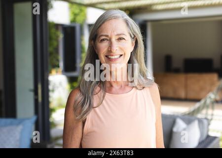 Zu Hause lächelt eine reife kaukasische Frau in die Kamera Stockfoto