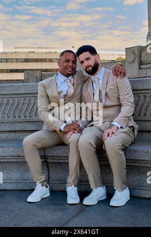 Zwei Jungs, die Hände halten, um ihre Liebe zu feiern. Sie sind verheiratet, sie lächeln vor der Kamera, LGBT-Community-Stolz. Stockfoto