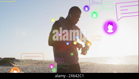 Bild von mehreren Symbolen, afroamerikaner, der Kopfhörer anpasst und Smartwatch betrachtet Stockfoto