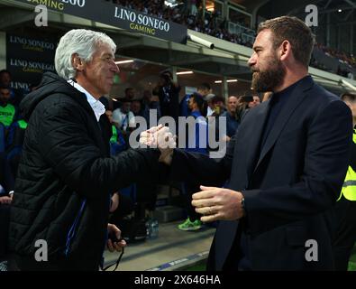 Bergamo, Italien. Mai 2024. Gian Piero Gasperini (L), Cheftrainer von Atalanta, schüttelt sich vor einem Fußball-Spiel der Serie A zwischen Atalanta und Roma in Bergamo, Italien, am 12. Mai 2024 die Hand mit Daniele de Rossi. Quelle: Alberto Lingria/Xinhua/Alamy Live News Stockfoto