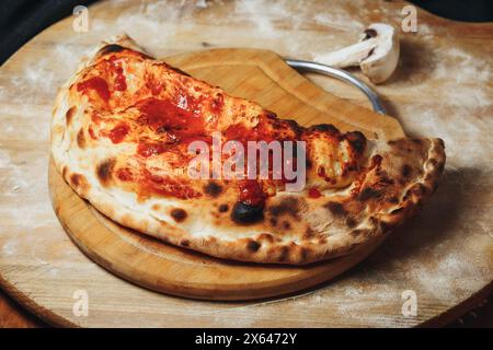 Rustikale Calzone auf einem Holzbrett Stockfoto