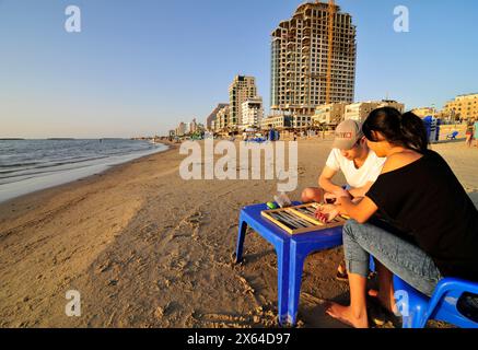 Ein Paar spielt Backgammon am Strand in Tel Aviv, Israel. Stockfoto