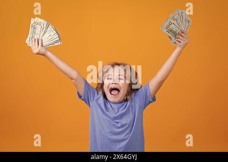 Amerikanische Träume. Ein reicher Junge mit Dollar. Lotterie-Cashback, gewinnen Sie viel Geld mit gelbem Hintergrund. Stockfoto