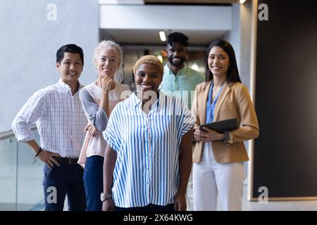 Das Team im Büro posiert zusammen und lächelt Stockfoto