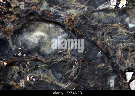 Foto der Steinstruktur. Makro. Verschiedene Braun-, Blau-, Grau- und Weißtöne. Der Stein ist mit dünnen, hellen Pastelllinien bedeckt. An Stellen, W Stockfoto