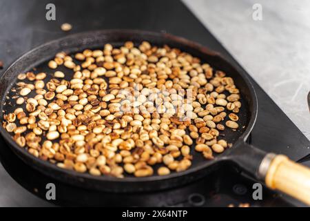 Mittelgeröstete Kaffeebohnen sind in einer Pfanne rauchig. Ausgewählter Fokus. Hochwertige Fotos Stockfoto