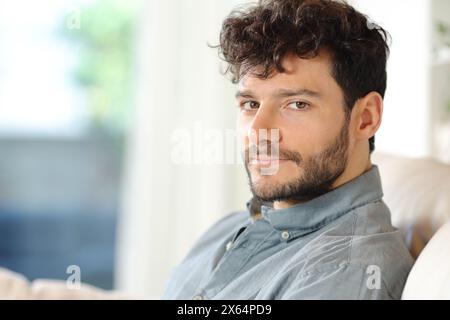Porträt eines ernsten, selbstbewussten Mannes, der zu Hause in die Kamera schaut Stockfoto