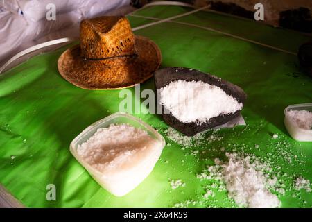 Ein grüner Tisch mit Hut und zwei Schüsseln Salz. Der Hut ist braun und hat ein schwarzes Band Stockfoto