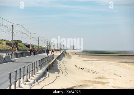 Die Küstenstraßenebahn Kusttram - de Lijn galt lange als die längste Straßenbahn Linie der Welt. Zwischen Knokke und de Panne befährt sie die gesamte Küste Belgiens. Hier in Raversijde zwischen Middelkerke und Oostende fährt die Bahn zwischen den Bunkern und Geschützen des ehemaligen Atlantikwalls und dem Strand. Im Hintergrund das markante Gebäude des Casino Middelkerke 12.05.2024 Oostende Raversijde Westflandern Belgien *** die Küstenstraßenbahn Kusttram de Lijn galt lange als die längste Straßenbahnlinie der Welt zwischen Knokke und de Panne, sie verläuft hier entlang der gesamten belgischen Küste Stockfoto