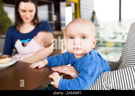 Neue Mom-Freunde gehen mit Babys ins Café. Gemeinsame Freizeit während des Mutterschaftsurlaubs in der Stadt. Stockfoto