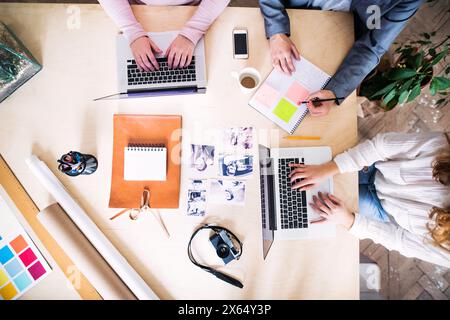 Draufsicht einer Gruppe von Kollegen, die gemeinsam an einem neuen Projekt in einem Startup-Unternehmen arbeiten. Arbeiten im Co-Working-Bereich. Stockfoto