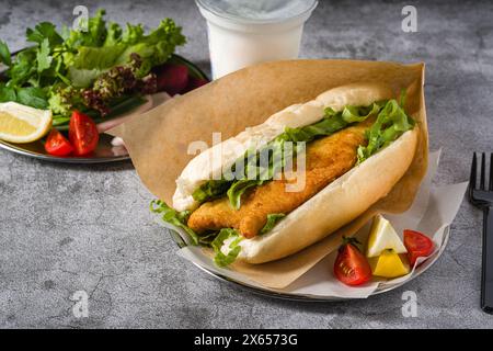 Gebratenes Fisch-Sandwich mit Gemüse auf dem Steintisch. Türkischer Name Balik Ekmek Stockfoto