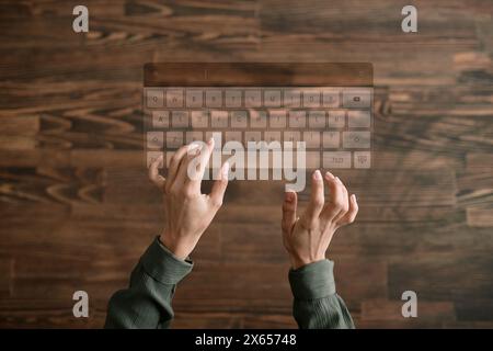 Von oben Bild von Händen einer unerkennbaren Frau, die auf virtueller Tastatur, hölzernem Hintergrund, Kopierraum tippt Stockfoto