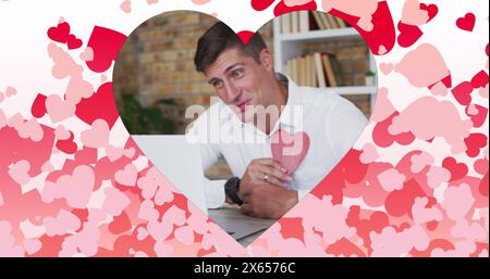 Bild eines herzförmigen Rahmens mit roten Herzen, die über den kaukasier fliegen Stockfoto