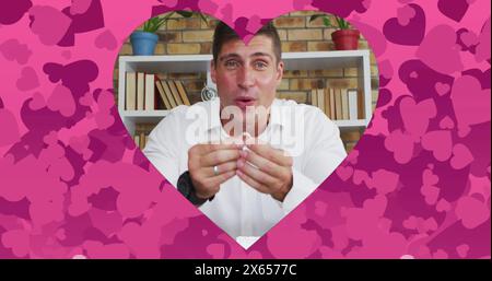Bild eines herzförmigen Rahmens über dem kaukasischen Mann, der mit einem Ring auf dem Laptop einen Bildruf vorschlägt Stockfoto